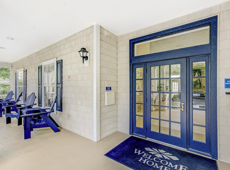 Clubhouse front entrance featuring blue trim, Adirondack style chairs and welcome home mat
